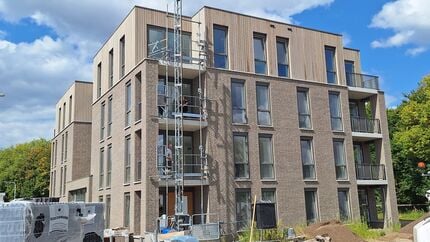 Nieuw appartementencomplex in aanbouw bij de Tuinderij in Zundert, met steigers langs de gevel en bouwmaterialen op de voorgrond.