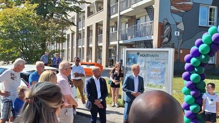Groep mensen verzameld op straat bij de opening van het Hout oe fit pad in Oosterhout, met ballonnenboog op de voorgrond en een zonnige dag.